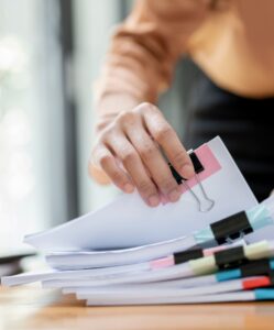 Closeup shot of a professional hand-picking a document from a pile.