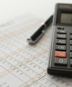 Financial accounting sheet with pen and calculator