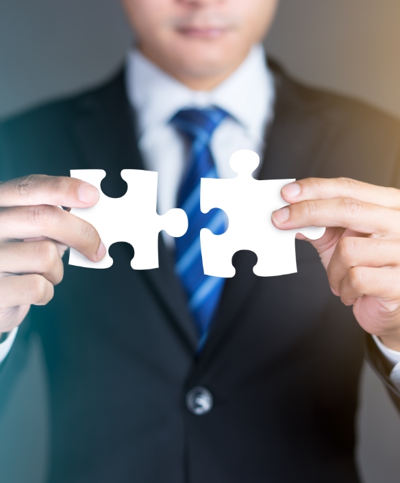 Businessman hands connecting puzzle pieces representing joint venture.