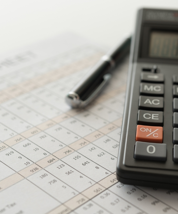 Financial accounting sheet with pen and calculator